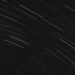 From below of bright glowing stars in long exposure on dark night sky